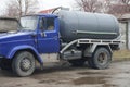 A large truck with a blue cab and a gray barrel