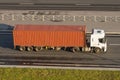 Large truck with container trailer on the highway asphalt, evening sunset light. View from above. Royalty Free Stock Photo