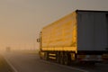 A truck is driving along the summer road in the morning in a thick fog Royalty Free Stock Photo
