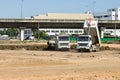 The large truck is dumping the soil on the construction site