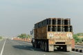 large truck on the road with large barrels on back of it