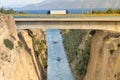 Large truck traversing the bridge of isthmus of Corinth in Greece while the boats are travelling in the bottom. Royalty Free Stock Photo