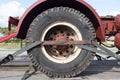 Large truck wheel secured with staps onto the back of a trailer for safe transport