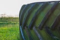 Large truck wheel tire on the grass under grey sky Royalty Free Stock Photo