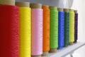 Large tubes with colored threads. Sewing production