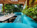 Large turquoise sofa and table on the terrace, cozy outdoor dining area