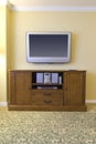 Large tv above wooden stereo cabinet