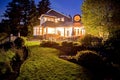 Large two story house with lots of lights in the summer evening. Royalty Free Stock Photo