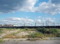 Large unused urban brownfield site with open land covered in cracked overgrown concrete awaiting development in leeds england