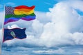 large US lgbtqflag and flag of Guam state, USA waving in wind at cloudy sky. Freedom and love concept. Pride month. activism,