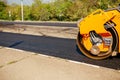 Large vibratory roller compact fresh asphalt on the road surface of a new construction site