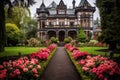 a large victorian mansion surrounded by lush gardens in full bloom Royalty Free Stock Photo