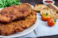 A large Viennese schnitzel on a dark wooden background