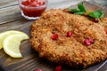 Large Viennese schnitzel on a wooden background. Meat dish.