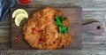 Large Viennese schnitzel on a wooden background. Meat dish.