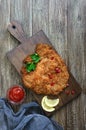 Large Viennese schnitzel on a wooden background.