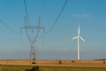 Windmill and powerline on the field Royalty Free Stock Photo