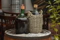 Large Vintage Wine Bottles in wicker basket on a barrel Royalty Free Stock Photo