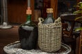 Large Vintage Wine Bottles in wicker basket on a barrel Royalty Free Stock Photo