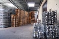 Large warehouse at the factory, winery, bottles of wine in metal baskets ready for transportation, piles of wooden pallets. Royalty Free Stock Photo