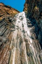 A large waterfall in the mountains. Waterfall in the Caucasus mountains. Waterfall in Chegem