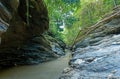 A large waterfall next to a rock wall, A scenic view in a forest in Wang Sila Lang, Nan, Thailand