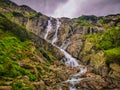 A large waterfall over a rocky cliff