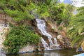 A large waterfall with radon water among boulders at the foot of a mountain in Loutraki, Greece