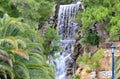 A large waterfall with radon water among boulders at the foot of a mountain in Loutraki, Greece