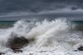 A large wave breaks on a rock