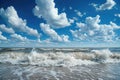 A large wave with powerful force rolls towards the shore, crashing against the sandy beach, Waves under the blue sky and white Royalty Free Stock Photo