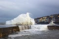Large waves from the Irish Sea during a winter storm batter the harbor wall at the long Hole in Bangor Ireland