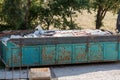 Construction Debris Dumpster: Rusted Turquoise Container Filled with Broken Window Frames, Wood, and Building Materials Outdoors Royalty Free Stock Photo