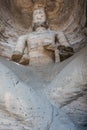 Large weatherworn Buddha statue in cave 17 of the Yungang Grottoes Royalty Free Stock Photo