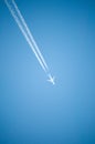 White jet plane flies high in the blue sky and leaves behind a white contrail Royalty Free Stock Photo