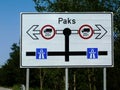 Large white aluminum board traffic sign on road side with trees along