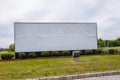 Large white blank roadside sign on a grass lawn with a light Royalty Free Stock Photo