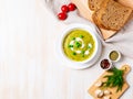 Large white bowl with vegetable green cream soup of broccoli, zucchini, green peas on white background, top view, copy space Royalty Free Stock Photo