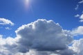 large white cloud against a bright blue sky. The cumulus nature of the clouds is a harbinger of a downpour Royalty Free Stock Photo