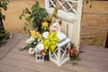 Large white decorative candle lantern and small candle lantern stand on terrace with flowers and autumn leaves. Wedding decor,