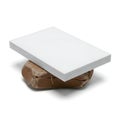 A large white foam block resting on a brown rock in a studio setting Royalty Free Stock Photo