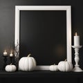 A large white frame with a black background inside next to white candles on a black shelf against a black wall