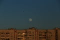 Large white full moon on clear blue over an urban high building Royalty Free Stock Photo