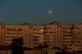Large white full moon on clear blue over an urban high building Royalty Free Stock Photo