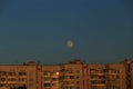Large white full moon on clear blue over an urban high building Royalty Free Stock Photo