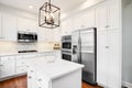 A large white kitchen with stainless steel appliances. Royalty Free Stock Photo