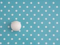 Large white marble ball amongst small dots on turquoise. Different, unique or just trying to adapt, fit in. Hiding in