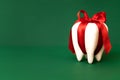 Large white modal molar is tied with a red ribbon with a bow