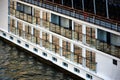 large white multi level hotel boat on the Danube river at sunset. warm brown and green tones Royalty Free Stock Photo