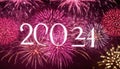 White 2024 text overlay on pink and red fireworks display Royalty Free Stock Photo